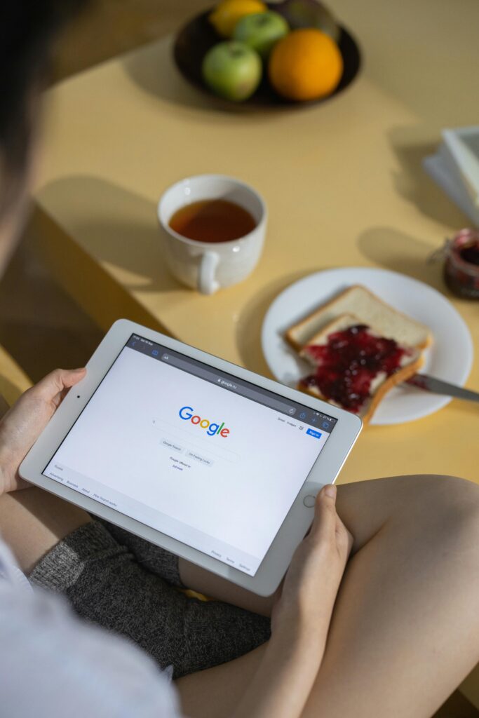 pexels-photo-7350905-7350905 Person using a tablet with Google search open while having breakfast with toast and tea.